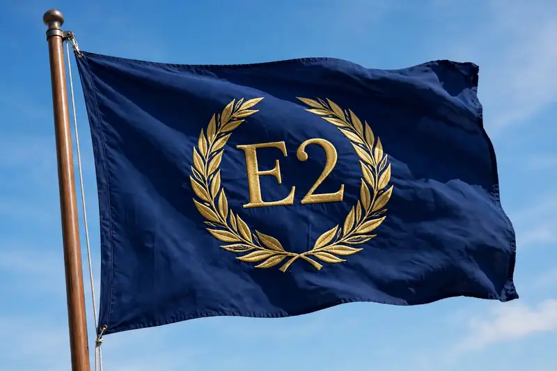 The E2 flag flying: navy blue with the gold laurel wreath E2 emblem